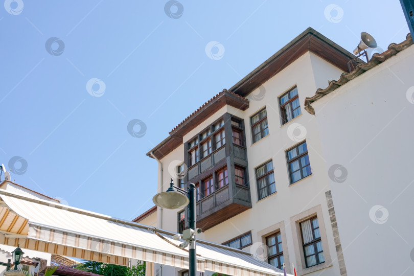 Скачать Белое здание с балконом и фонарным столбом фотосток Ozero