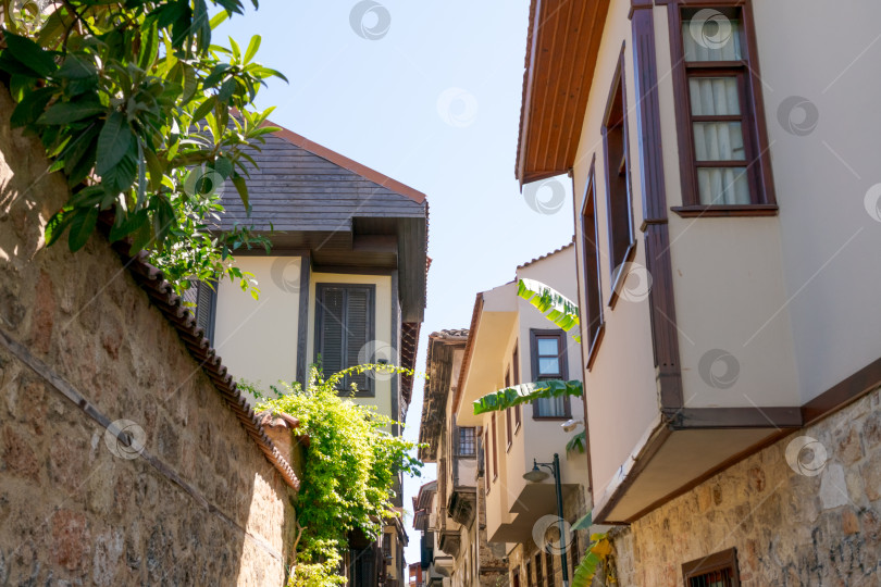 Скачать Узкий переулок с каменной стеной и рядом домов фотосток Ozero