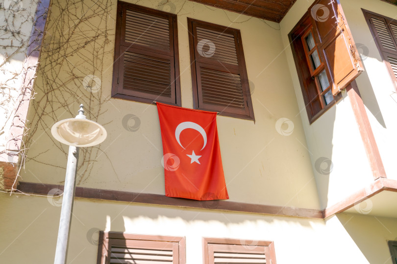 Скачать На здании висит красно-белый флаг со звездой фотосток Ozero