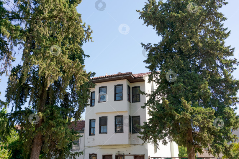 Скачать Белое здание с красной крышей и рядом окон фотосток Ozero