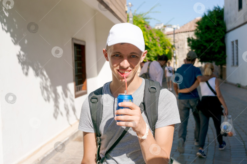 Скачать Мужчина в белой шляпе пьет газировку из банки фотосток Ozero