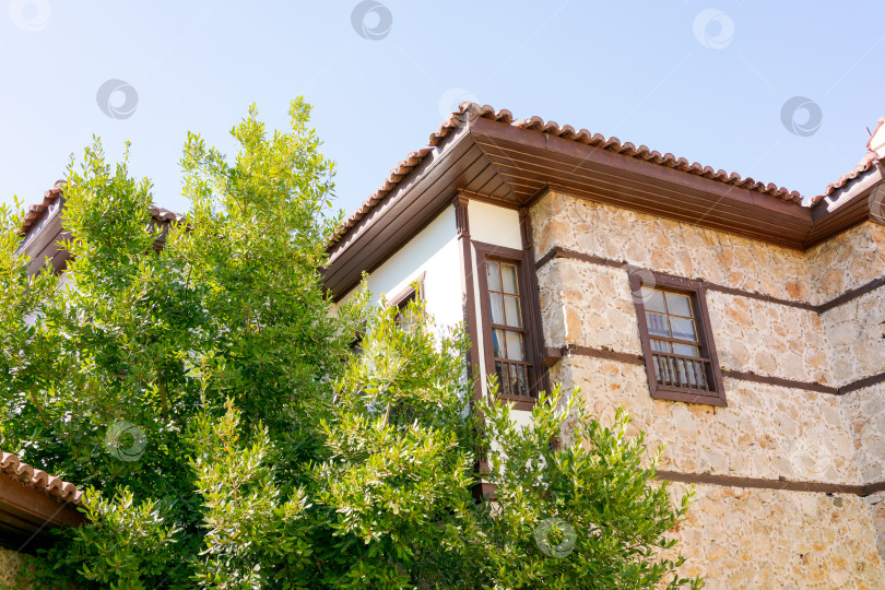 Скачать Дом с коричневой крышей и зеленым деревом перед ним фотосток Ozero