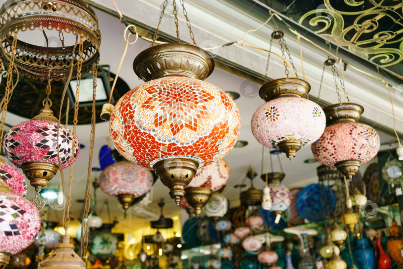 Скачать Ряд разноцветных стеклянных ламп, свисающих с потолка фотосток Ozero
