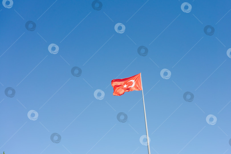 Скачать В небе развевается красный флаг с белой звездой на нем фотосток Ozero