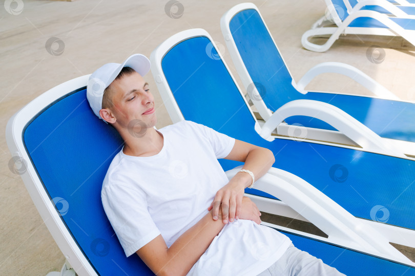 Скачать Мужчина лежит в синем шезлонге фотосток Ozero