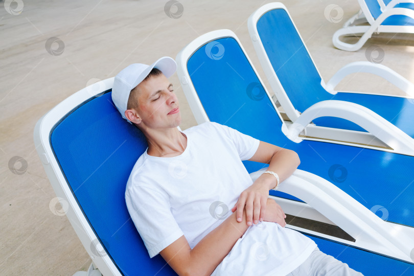 Скачать Мужчина лежит в синем шезлонге фотосток Ozero