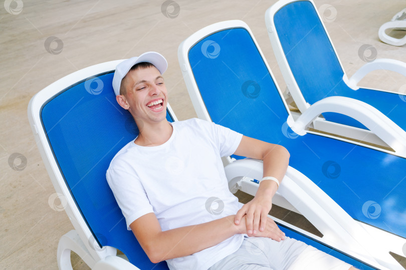 Скачать Мужчина сидит в синем шезлонге фотосток Ozero