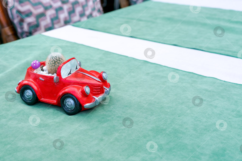 Скачать Красная игрушечная машинка стоит на зеленой скатерти фотосток Ozero