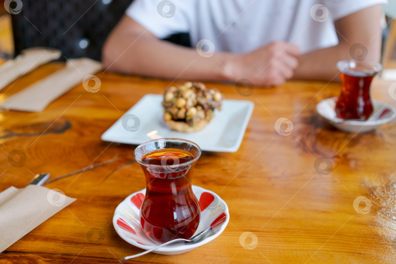 Скачать Человек сидит за столом с тарелкой еды и чашкой чая фотосток Ozero