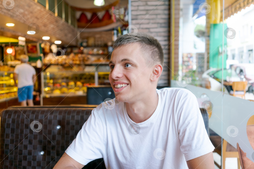 Скачать Мужчина в белой рубашке сидит за столиком в ресторане фотосток Ozero