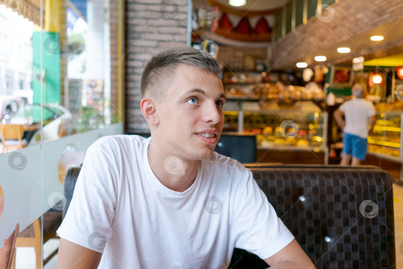 Скачать Мужчина в белой рубашке сидит за столиком в ресторане фотосток Ozero