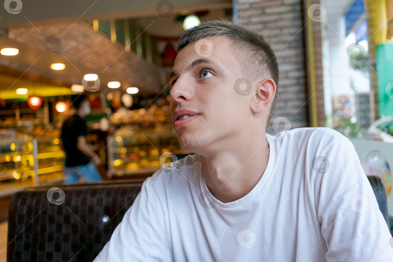 Скачать Мужчина в белой рубашке сидит за столиком в ресторане фотосток Ozero