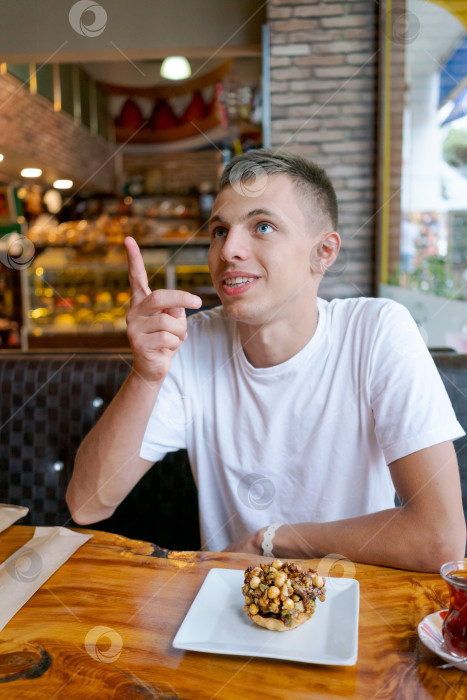 Скачать Мужчина сидит за столом, перед ним стоит тарелка с едой фотосток Ozero