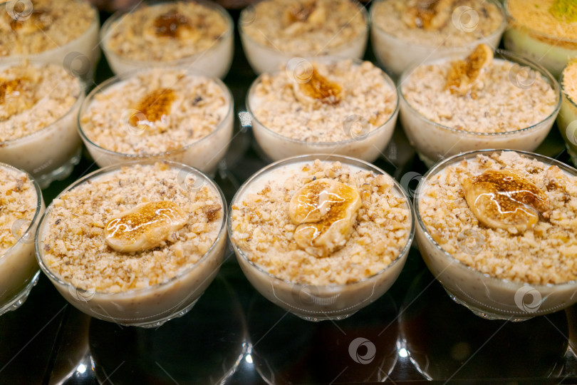 Скачать Ряд маленьких мисочек, наполненных десертом, приготовленным с орехами и бананами фотосток Ozero