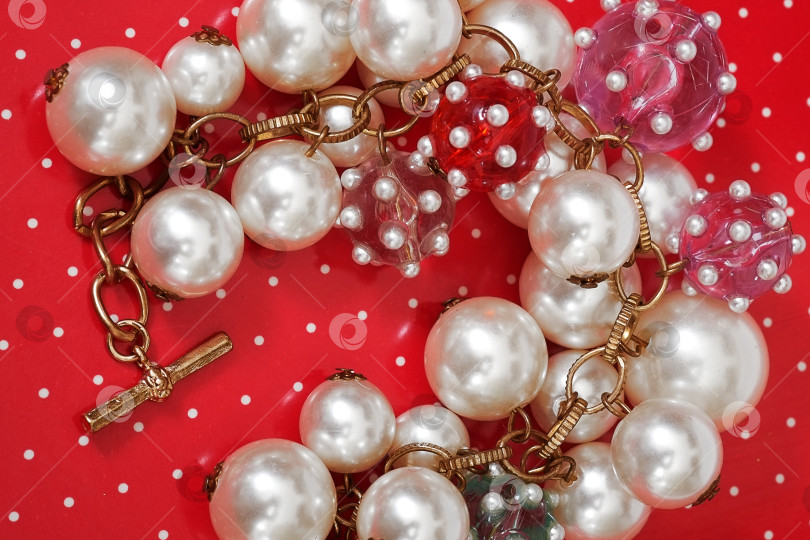 Скачать Браслет из жемчуга, выделяющийся на красном фоне фотосток Ozero