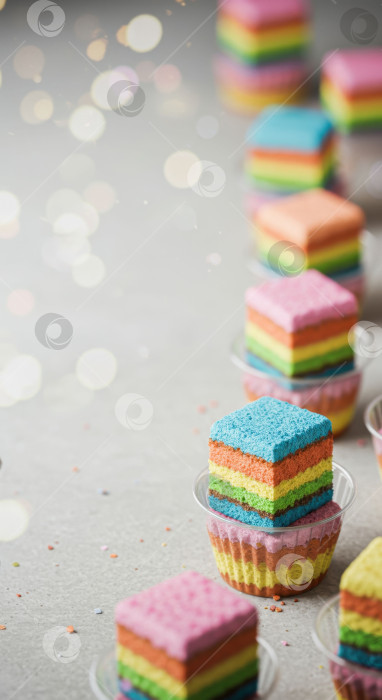 Скачать Разноцветные радужные кусочки торта с множеством ярких слоев десертов и вкусных сладких блюд. Концепция оформления кондитерских изделий для вечеринки или торжества. фотосток Ozero