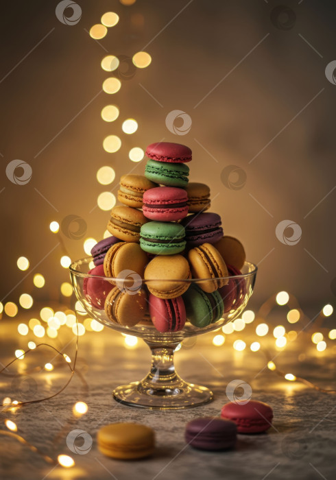 Скачать Стопка разноцветных французских макарон в стеклянной миске на праздничном фоне с подсветкой в виде боке. Сладкий десерт для праздничного застолья. фотосток Ozero