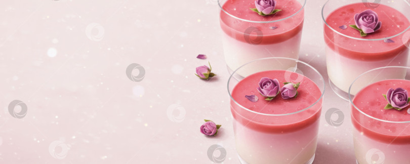 Скачать Вкусный десерт с многослойной розовой и белой панна-коттой, украшенной декоративным цветком розы на розовом фоне, по рецепту сладкого. фотосток Ozero