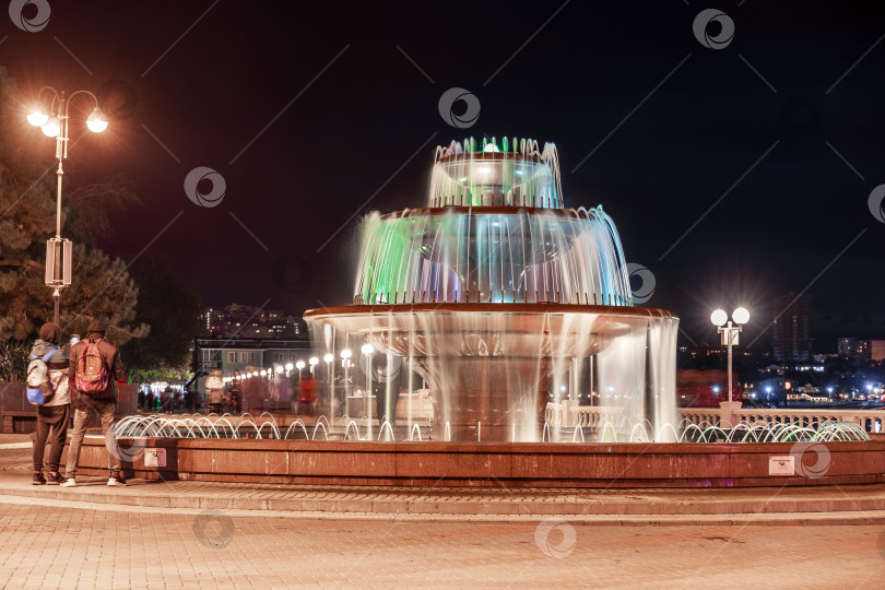 Скачать Геленджик, Краснодарский край, Россия, 19 декабря 2024 года.  Курорт Геленджик, Черное море, музыкальный фонтан. Большой фонтан с красной водой подсвечивается ночью фотосток Ozero