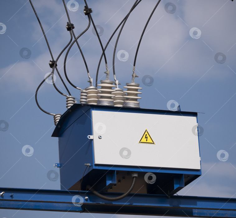 Скачать Электрический трансформатор с проводами и изолятором на фоне неба фотосток Ozero