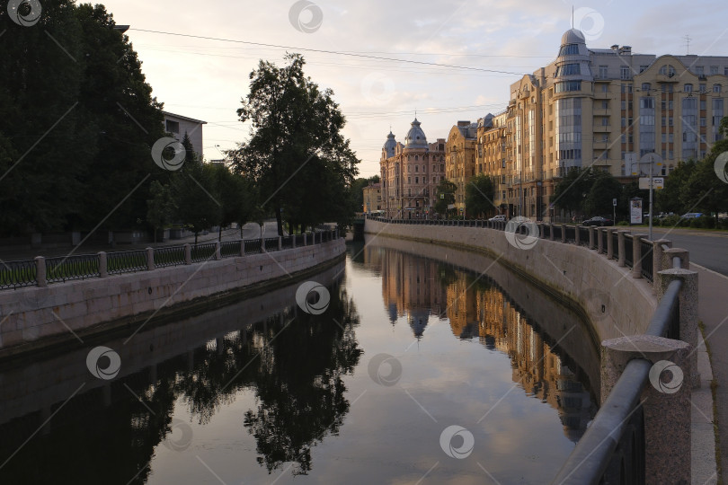Скачать Отражение домов в спокойной воде канала на реке Карповка ранним утром. фотосток Ozero