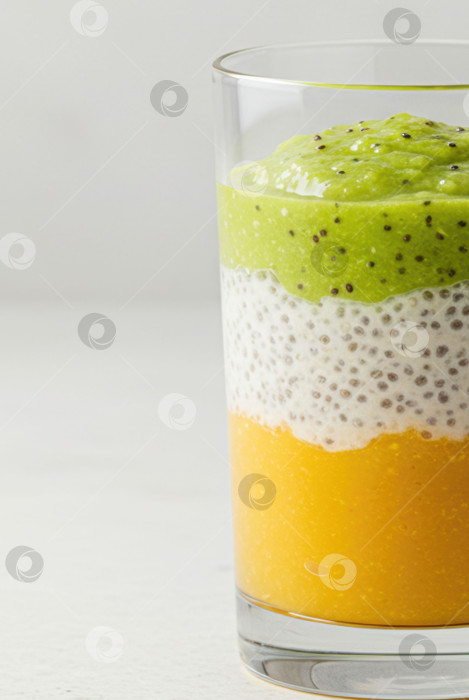 Скачать Яркий десерт из чиа-пудинга в бокале с киви и манго. Сладкое блюдо с многослойной текстурой. Концепция здорового питания. фотосток Ozero