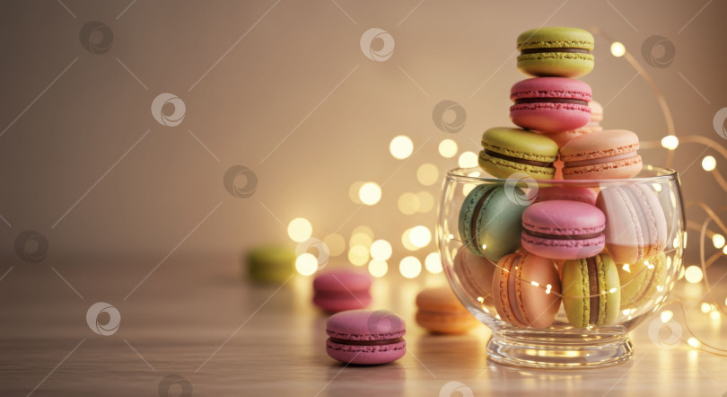 Скачать Разложенные в бокале разноцветные французские конфеты из теста макарон на столе в теплом свете боке фотосток Ozero