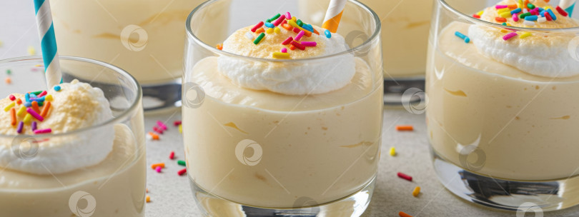 Скачать Крупный план формочек для ванильного пудинга с поджаренной меренгой и разноцветной посыпкой. Десерт для вечеринки или торжества. фотосток Ozero