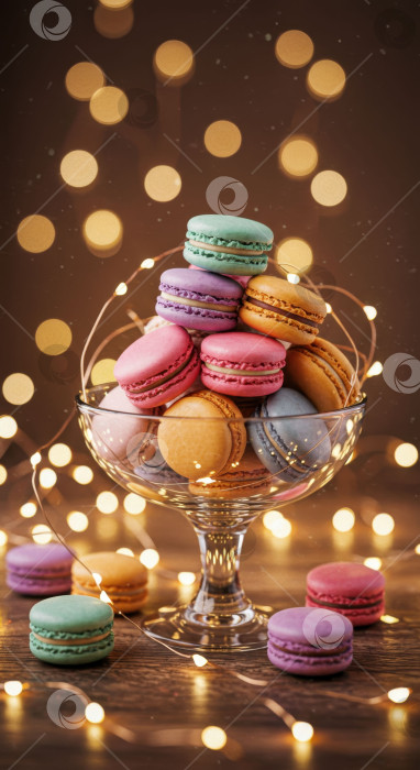 Скачать Разноцветная пирамидка из макарон в стеклянной вазе с гирляндами. фотосток Ozero