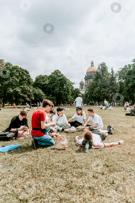 Скачать Санкт-Петербург, Россия, 2 июля 2020 года, поляна для подросткового пикника, Исаакиевский собор фотосток Ozero