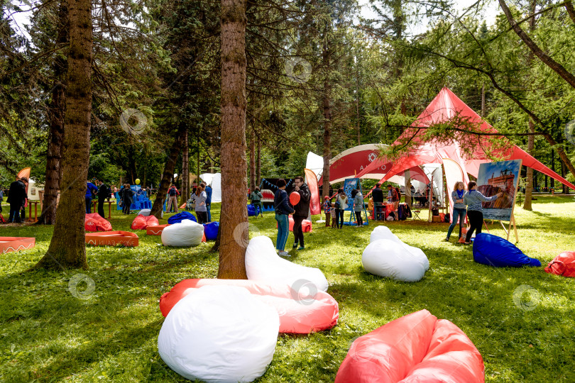 Скачать Санкт-Петербург, Россия, 6 июля 2019 года, Люди веселятся на зеленой траве в парке фотосток Ozero