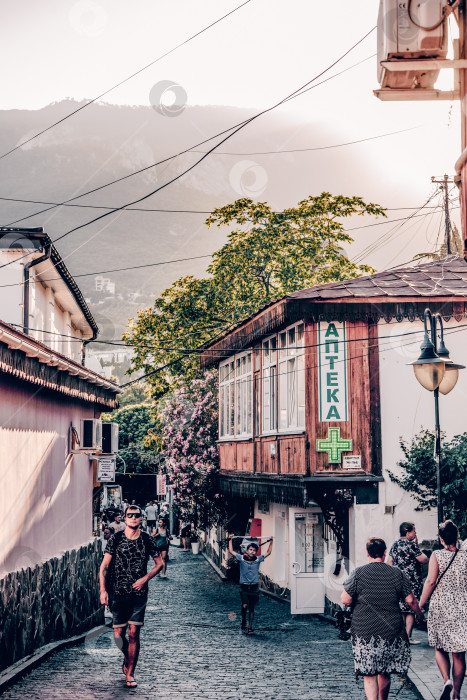 Скачать Гурзуф, Крым, 10 июля 2020 года, люди идут по узкой городской улочке маленького городка фотосток Ozero