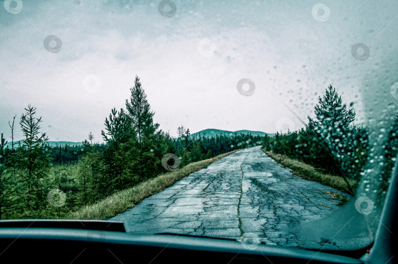 Скачать Вид из переднего окна автомобиля на асфальтированную разбитую пригородную дорогу шоссе фотосток Ozero