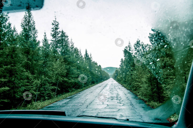 Скачать Вид из переднего окна автомобиля на асфальтированную разбитую пригородную дорогу шоссе фотосток Ozero