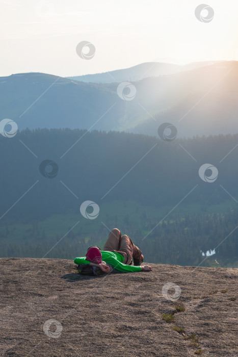 Скачать Женщина-турист отдыхает после восхождения на закате. фотосток Ozero