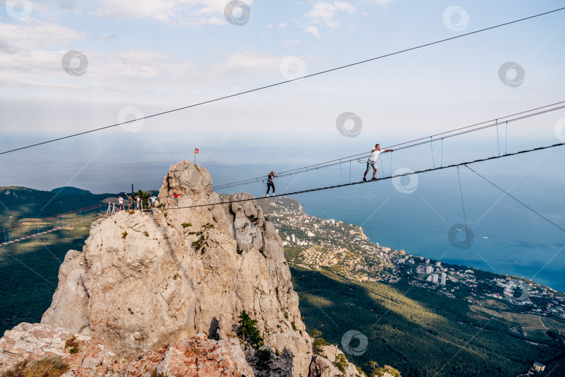 Скачать Ай-Петри, Крым, 22 июля 2020 года, туристы взбираются по подвесному мосту между скалами фотосток Ozero