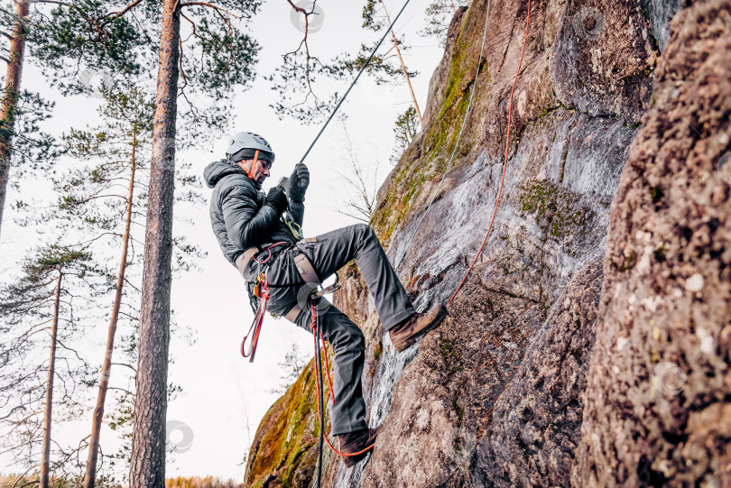 Скачать Санкт-Петербург, Россия, 4 января 2020 года, Скалолаз взбирается на высокую скальную стену фотосток Ozero