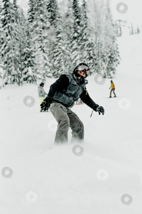 Скачать Шерегеш, Россия, 4 января 2021 года, лыжник-сноубордист скатывается по заснеженному склону фотосток Ozero