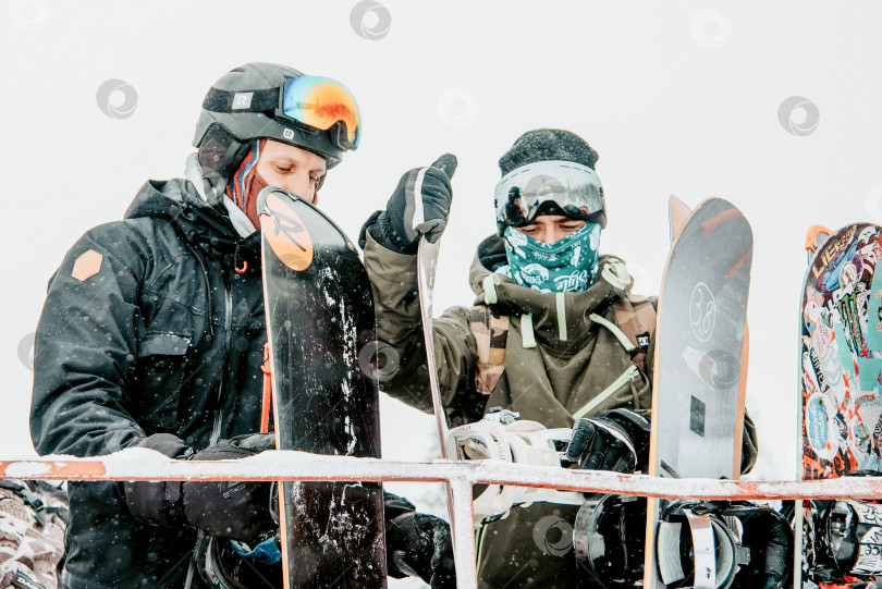 Скачать Шерегеш, Россия, 4 января 2021 года, Сноубордист, лыжник загружает лыжное снаряжение snowcat фотосток Ozero