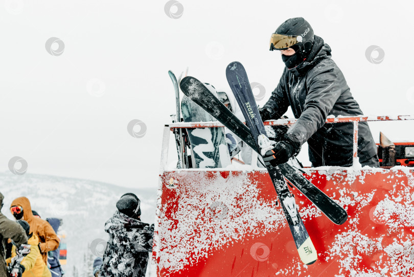 Скачать Шерегеш, Россия, 4 января 2021 года, сноубордист-лыжник вылезает из снегохода фотосток Ozero
