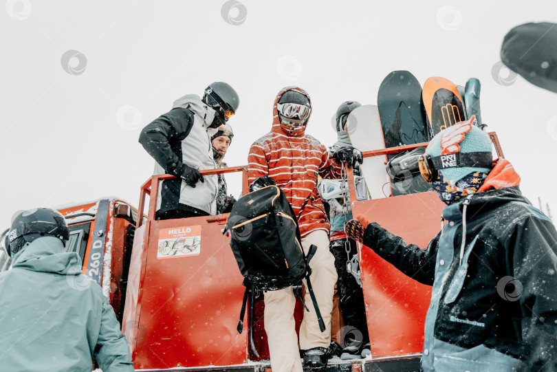 Скачать Шерегеш, Россия, 4 января 2021 года, сноубордист-лыжник вылезает из снегохода фотосток Ozero