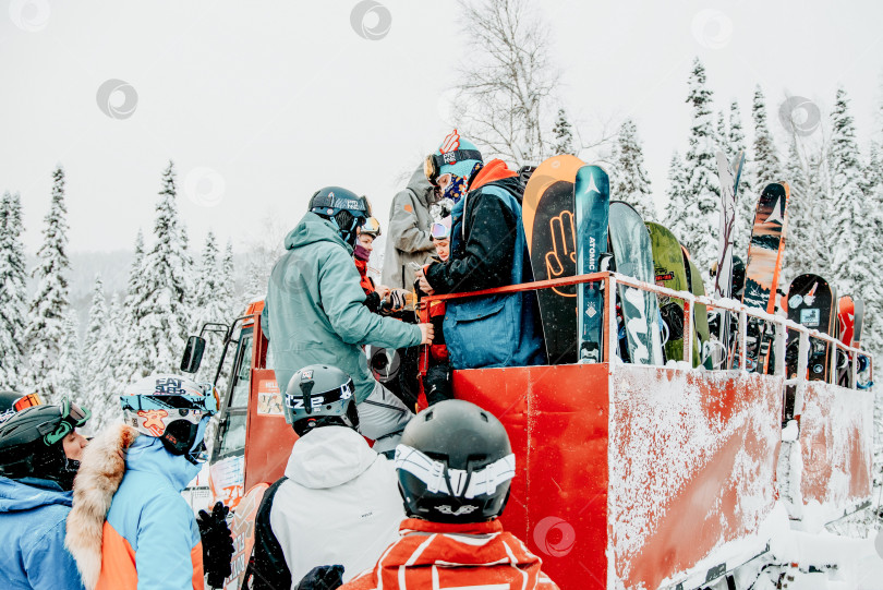 Скачать Шерегеш, Россия, 4 января 2021 года, Сноубордист, лыжник загружает лыжное снаряжение snowcat фотосток Ozero