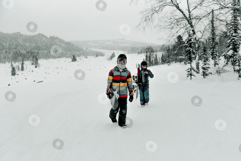 Скачать Шерегеш, Россия, 4 января 2021 года, Сноубордист-лыжник идет пешком и держит в руках сноуборд фотосток Ozero