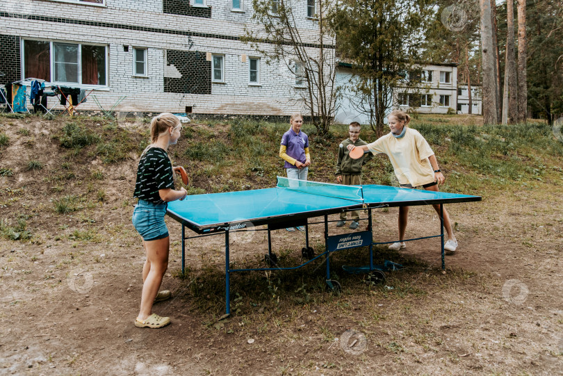 Скачать Санкт-Петербург, Россия, 23 июля 2020 года, Дети и подростки играют в любительский матч по настольному теннису на открытом воздухе фотосток Ozero