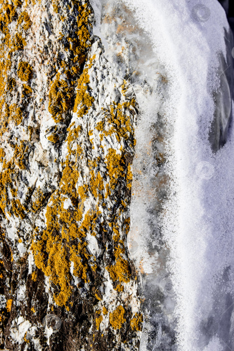 Скачать Ледяные сосульки, свисающие с каменной поверхности пещеры, замерзшая вода озера Байкал зимой фотосток Ozero