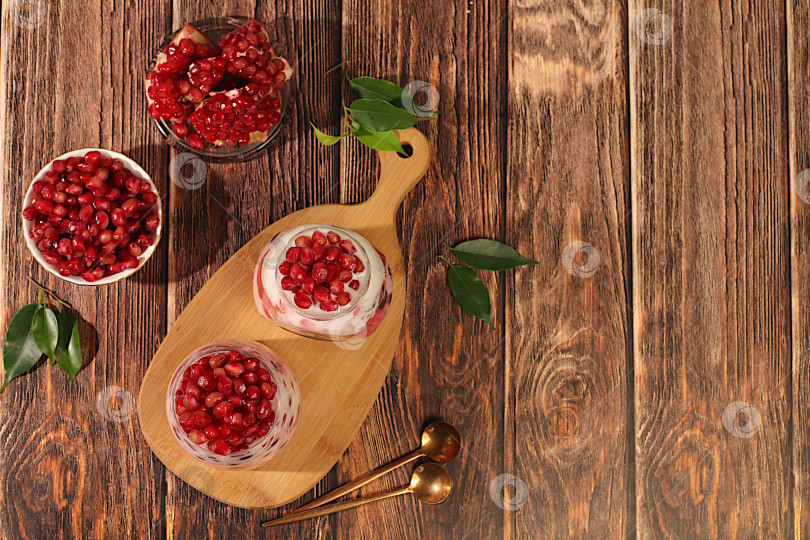 Скачать Фруктовый йогурт с гранатом, изюмом и свежими сливками из коровьего молока для здорового питания. Полезный завтрак с ингредиентами, история кухни. Концепция натурального питания и детокс-диеты, меню для кафе фотосток Ozero