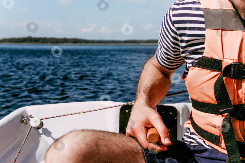 Скачать Мужчина-турист, управляющий деревянной парусной лодкой на Ладожском озере в Карелии, Россия фотосток Ozero