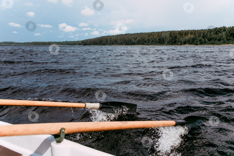 Скачать Туристы плывут на деревянной весельной лодке по Ладожскому озеру в Карелии, Россия фотосток Ozero