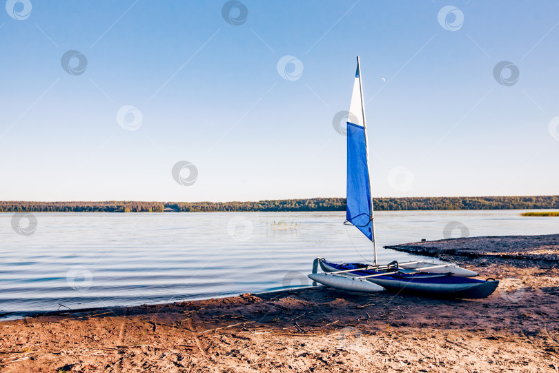 Скачать Байдарка-каноэ с парусом пришвартована на берегу Ладожского озера в Карелии, Россия фотосток Ozero