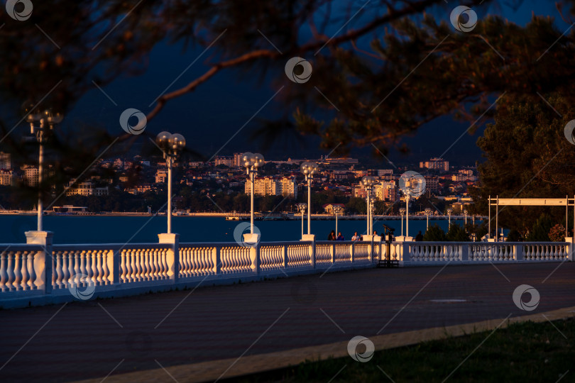 Скачать Курорт Геленджик. Набережная на закате. Балюстрада и набережная в косых лучах заходящего солнца. Кавказские горы на заднем плане. фотосток Ozero